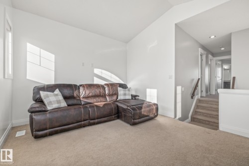 Carpeted living room with stairway and lofted ceiling - 167 Bremner Crescent, Fort Saskatchewan, AB - Indoor