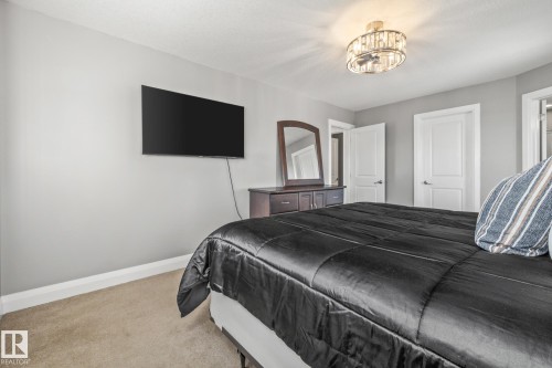 Carpeted bedroom featuring baseboards and suspended lighting - 167 Bremner Crescent, Fort Saskatchewan, AB - Indoor Photo Showing Bedroom