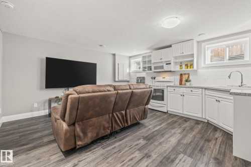 Living room featuring dark wood-style floors, plenty of natural light, and a textured ceiling - 167 Bremner Crescent, Fort Saskatchewan, AB - Indoor Photo Showing Kitchen
