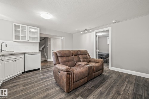 Living room featuring a textured ceiling, dark wood finished floors, and rail lighting - 167 Bremner Crescent, Fort Saskatchewan, AB - Indoor