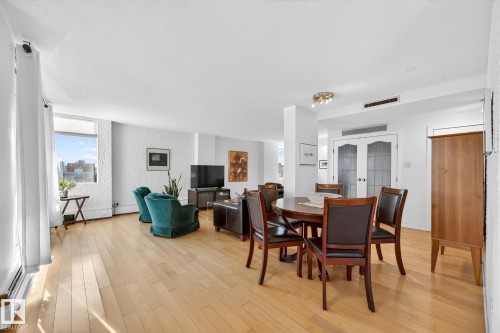 Dining space with french doors, light wood-style floors, and a textured wall - 1502 10160 115 Street, Edmonton, AB - Indoor Photo Showing Dining Room