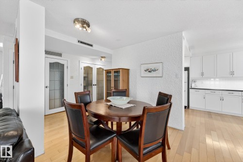 Dining room featuring french doors, a textured wall, and light wood-style floors - 1502 10160 115 Street, Edmonton, AB - Indoor Photo Showing Dining Room