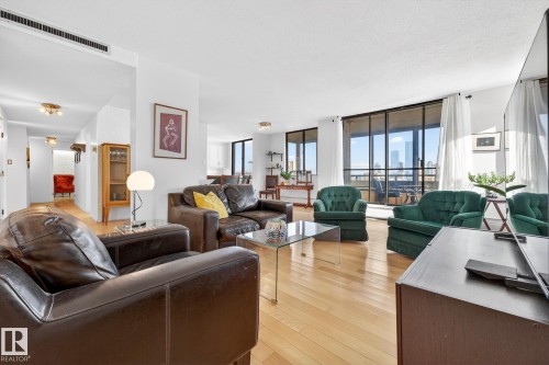 Living room featuring light wood-style floors and expansive windows - 1502 10160 115 Street, Edmonton, AB - Indoor Photo Showing Living Room