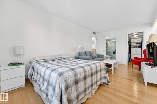 Bedroom featuring light wood-style floors, a walk in closet, and ensuite bath - 1502 10160 115 Street, Edmonton, AB - Indoor Photo Showing Bedroom