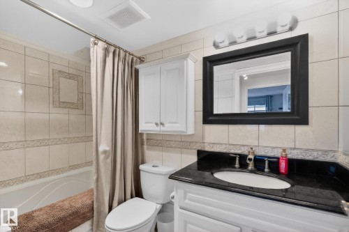 Bathroom with tile walls, vanity, shower / tub combo, and decorative backsplash - 1502 10160 115 Street, Edmonton, AB - Indoor Photo Showing Bathroom