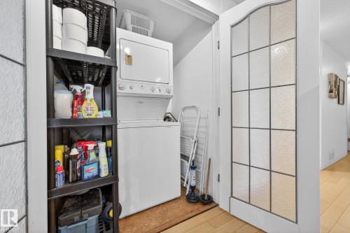 Laundry area with light wood finished floors and stacked washer / drying machine - 1502 10160 115 Street, Edmonton, AB - Indoor