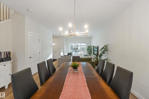 Dining area featuring a chandelier and wood finished floors - 72 Penn Place, Spruce Grove, AB - Indoor Photo Showing Dining Room