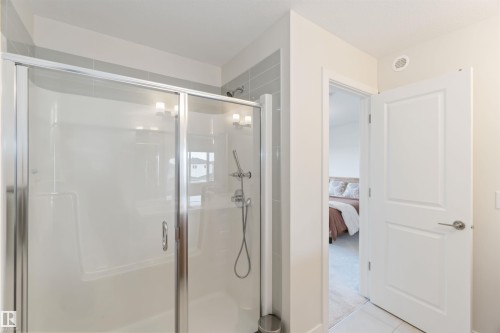 Bathroom with a shower stall, connected bathroom, and light tile patterned floors - 72 Penn Place, Spruce Grove, AB - Indoor Photo Showing Bathroom