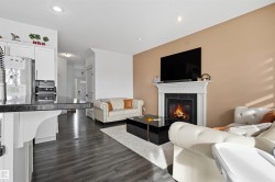 Living room featuring dark wood-style floors, a fireplace, and recessed lighting - 