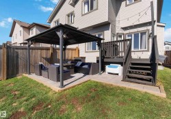 Back of property with outdoor lounge area, a patio, a gazebo, a fenced backyard, and a wooden deck - 