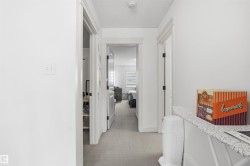 Hall featuring light carpet and a textured ceiling - 