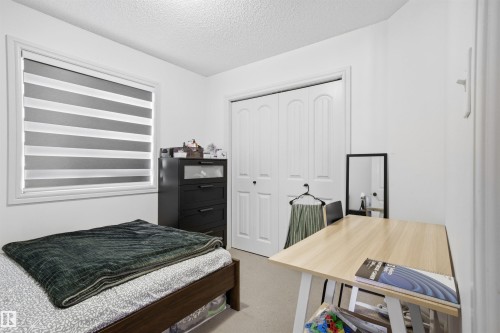Bedroom featuring light colored carpet, a textured ceiling, a desk, and a closet - 1965 118 Street, Edmonton, AB - Indoor Photo Showing Bedroom