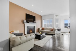 Living area with a fireplace, dark wood finished floors, and recessed lighting - 