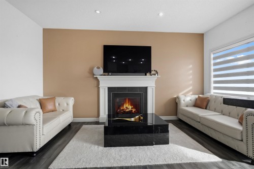 Living area with wood finished floors and a fireplace - 1965 118 Street, Edmonton, AB - Indoor Photo Showing Living Room With Fireplace