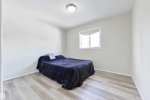 Bedroom with light wood-style floors and a textured ceiling - 11522 128 Street, Edmonton, AB - Indoor Photo Showing Bedroom
