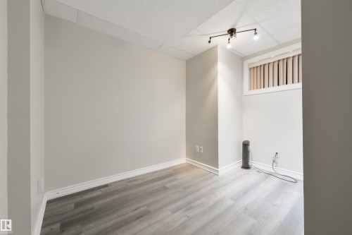 Spare room featuring a drop ceiling and wood finished floors - 11522 128 Street, Edmonton, AB - Indoor Photo Showing Other Room