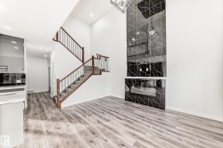 Unfurnished living room with light wood finished floors, a towering ceiling, recessed lighting, and stairs - 
