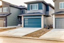 View of front of property with concrete driveway, an attached garage, and a shingled roof - 