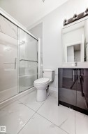 Bathroom featuring a shower stall and vanity - 
