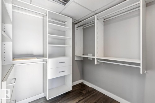 Walk in closet with dark wood finished floors and a drop ceiling - 3300 10180 103 Street, Edmonton, AB - Indoor With Storage