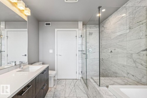 Full bath featuring vanity, a marble finish shower, light marble finish flooring, and recessed lighting - 3300 10180 103 Street, Edmonton, AB - Indoor Photo Showing Bathroom