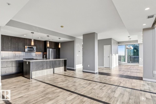 Kitchen with open floor plan, modern cabinets, a kitchen island with sink, stainless steel appliances, and backsplash - 3300 10180 103 Street, Edmonton, AB - Indoor Photo Showing Kitchen With Stainless Steel Kitchen
