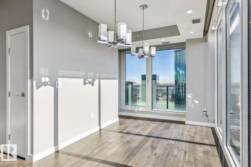 Unfurnished dining area featuring light wood-style flooring and suspended lighting - 3300 10180 103 Street, Edmonton, AB - Indoor Photo Showing Other Room