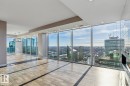Unfurnished living room featuring floor to ceiling windows, light wood-style flooring, a view of city, and a chandelier - 3300 10180 103 Street, Edmonton, AB  - Indoor Photo Showing Other Room 