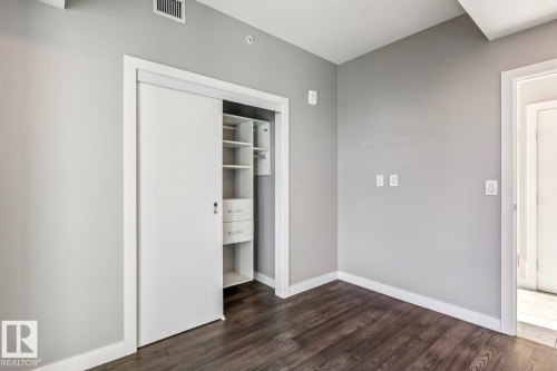 Unfurnished bedroom featuring dark wood finished floors and a closet - 3300 10180 103 Street, Edmonton, AB - Indoor Photo Showing Other Room