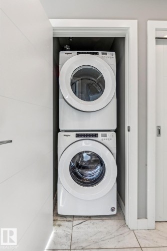 Laundry area featuring stacked washer and clothes dryer - 3300 10180 103 Street, Edmonton, AB - Indoor Photo Showing Laundry Room