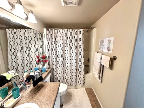 Bathroom with shower / bath combo with shower curtain and vanity - 215 13625 34 Street, Edmonton, AB - Indoor Photo Showing Bathroom