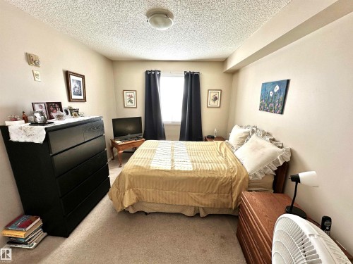 Carpeted bedroom with a textured ceiling - 215 13625 34 Street, Edmonton, AB - Indoor Photo Showing Bedroom