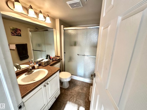 Full bathroom featuring vanity, a shower stall, and stone finish floors - 215 13625 34 Street, Edmonton, AB - Indoor Photo Showing Bathroom
