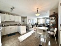 Kitchen featuring dark countertops, a peninsula, decorative light fixtures, white cabinets, and a textured ceiling - 215 13625 34 Street, Edmonton, AB  - Indoor 