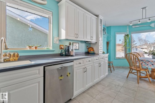 Kitchen featuring dishwasher, dark countertops, and white cabinets - 4231 39 Avenue, Leduc, AB - Indoor