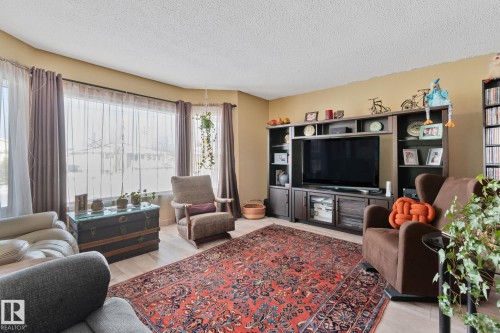 Living area with light wood-style floors and a textured ceiling - 4231 39 Avenue, Leduc, AB - Indoor Photo Showing Living Room