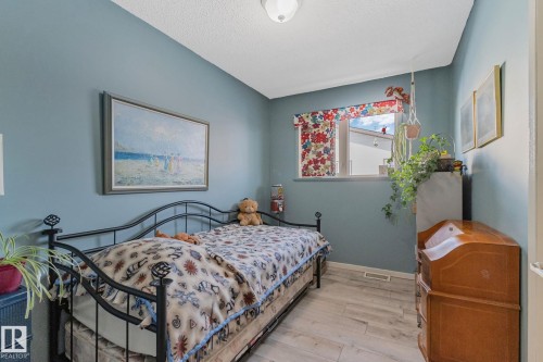 Bedroom featuring light wood finished floors and a textured ceiling - 4231 39 Avenue, Leduc, AB - Indoor Photo Showing Bedroom