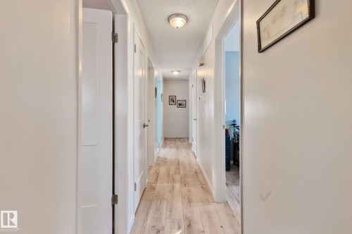 Hall with a textured ceiling and light wood-style flooring - 4231 39 Avenue, Leduc, AB - Indoor Photo Showing Other Room