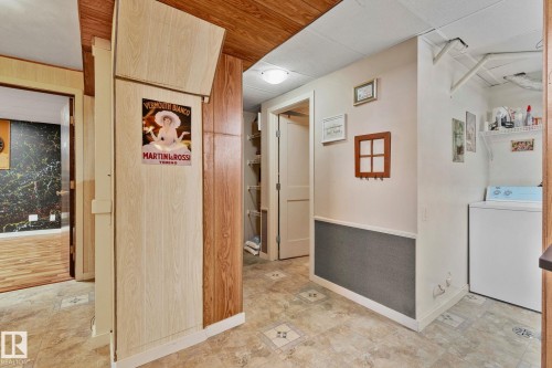 Hall with washer / dryer and wooden walls - 4231 39 Avenue, Leduc, AB - Indoor Photo Showing Laundry Room