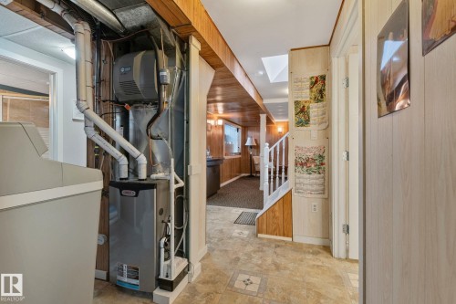 Below grade area featuring wooden walls, washer / dryer, and heating unit - 4231 39 Avenue, Leduc, AB - Indoor Photo Showing Basement