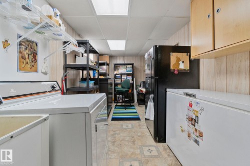 Laundry area featuring a drop ceiling and wooden walls - 4231 39 Avenue, Leduc, AB - Indoor Photo Showing Laundry Room