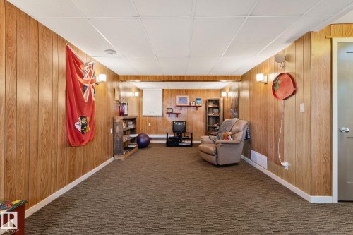 Sitting room with wooden walls and carpet floors - 4231 39 Avenue, Leduc, AB - Indoor Photo Showing Other Room