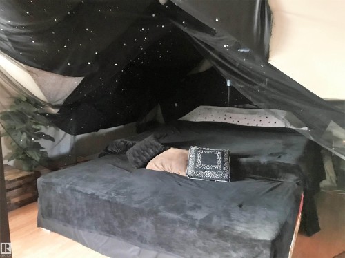 Home theater room featuring wood finished floors - 4735 48 Ave, Evansburg, AB - Indoor Photo Showing Bedroom