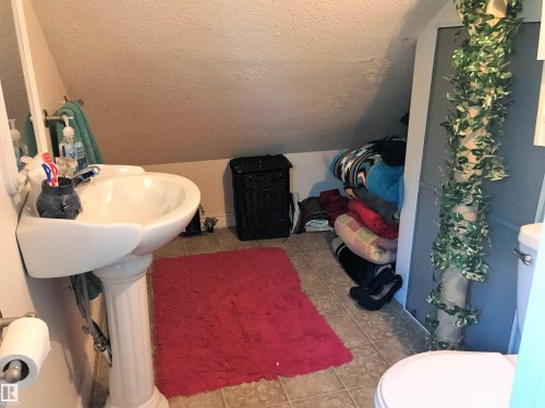 Bathroom featuring toilet and light tile patterned floors - 4735 48 Ave, Evansburg, AB - Indoor Photo Showing Bathroom