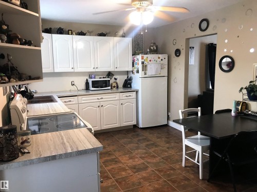 Kitchen featuring white cabinets, white appliances, ceiling fan, and light countertops - 4735 48 Ave, Evansburg, AB - Indoor Photo Showing Kitchen
