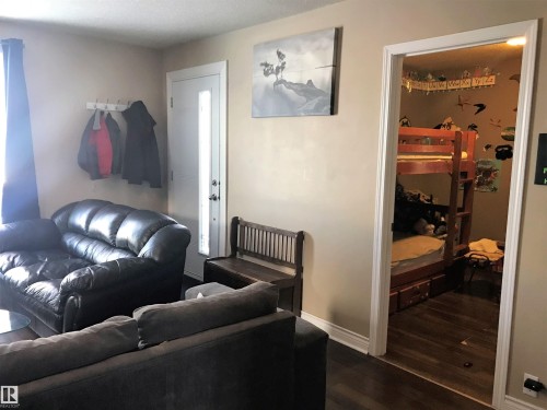 Living area featuring dark wood-style flooring and baseboards - 4735 48 Ave, Evansburg, AB - Indoor