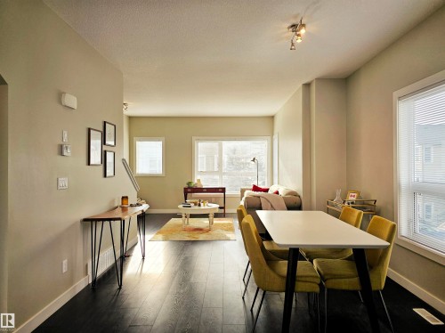 Dining room featuring dark wood finished floors and a textured ceiling - 129 2560 Pegasus Boulevard, Edmonton, AB - Indoor