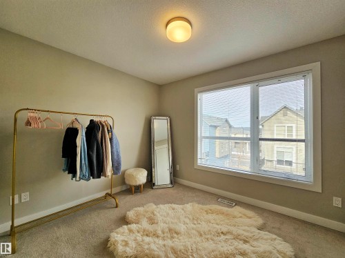 Bedroom with carpet flooring and a textured ceiling - 129 2560 Pegasus Boulevard, Edmonton, AB - Indoor