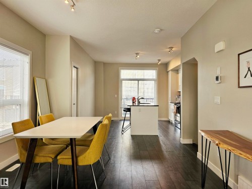 Dining room with dark wood-style floors and baseboards - 129 2560 Pegasus Boulevard, Edmonton, AB - Indoor Photo Showing Dining Room