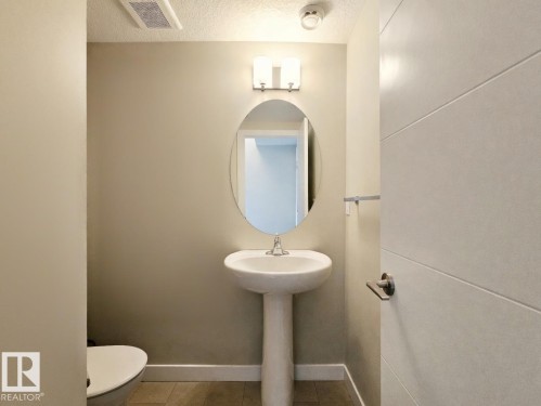 Half bath featuring a textured ceiling and toilet - 129 2560 Pegasus Boulevard, Edmonton, AB - Indoor Photo Showing Bathroom